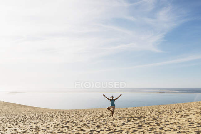 Жінка дивиться на Атлантичний океан під час вправ на пляжі в сонячний день, Дюна Пілата, Нувель-Аквітанія, Франція. — стокове фото