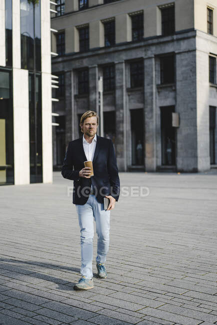 Бізнесмен з кавою, що ходить по місту. — стокове фото