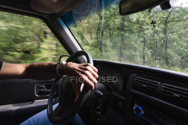 Main de l'homme au volant conduisant pendant le voyage — Photo de stock