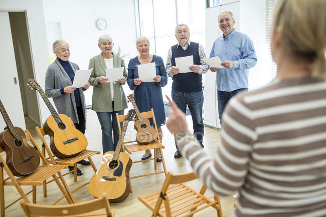 Пожилые люди в доме престарелых поют в хоре — стоковое фото