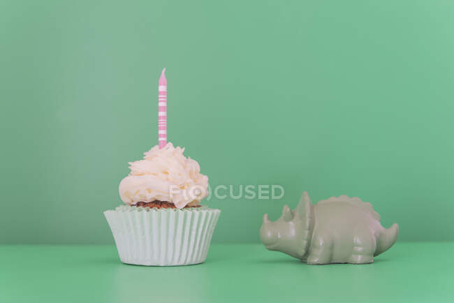 Birthday cupcake and toy triceratops — Stock Photo