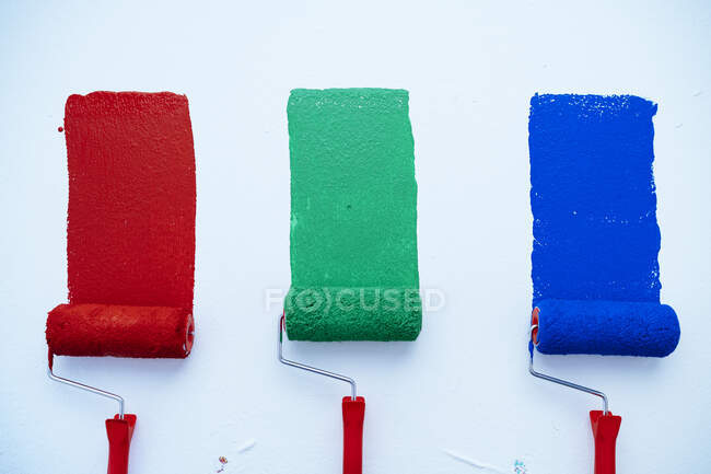 Rulli di verniciatura con vernice rossa, verde e blu — Foto stock
