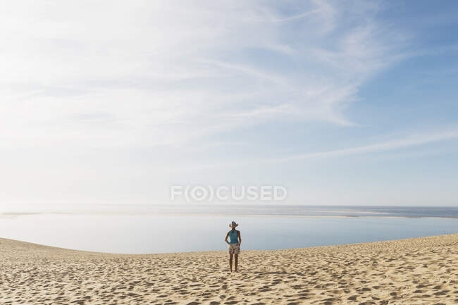 Жінка дивиться на Атлантичний океан стоячи на пляжі в сонячний день, Дюна Пілата, Нувель-Аквітанія, Франція. — стокове фото