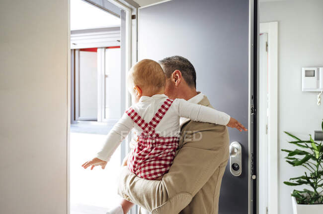Vater hält seinen kleinen Jungen in der Hand und verlässt das Haus — Stockfoto