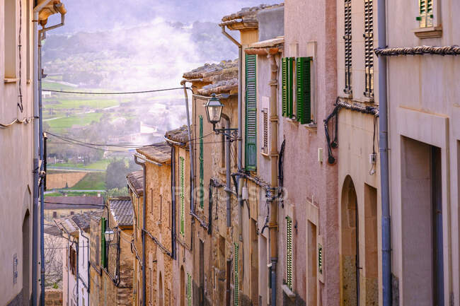 España, Mallorca, Montuiri, Fila de casas antiguas a lo largo de calle empinada - foto de stock
