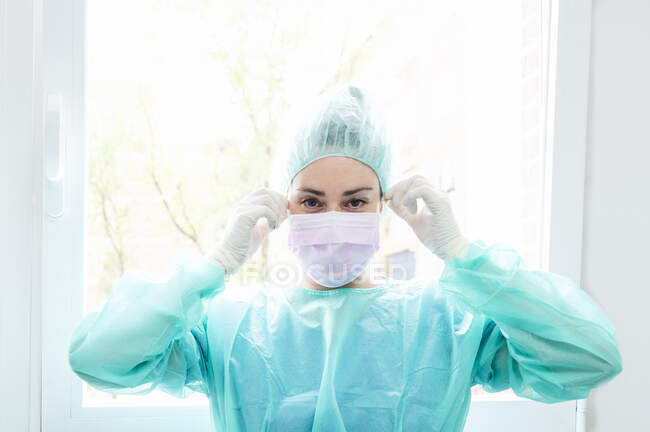 Зв'язок медсестри з хірургічною маскою на вікні лікарні. — стокове фото
