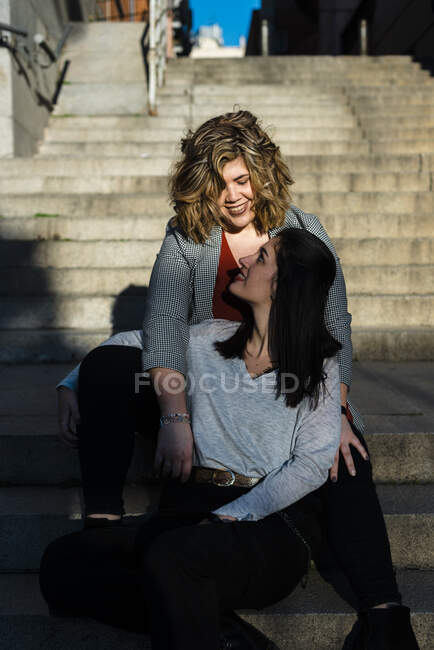 Coppia lesbica che si guarda mentre si siede sui gradini della città — Foto stock