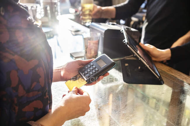 Жіночий клієнт платить кредитною карткою на кафе. — стокове фото