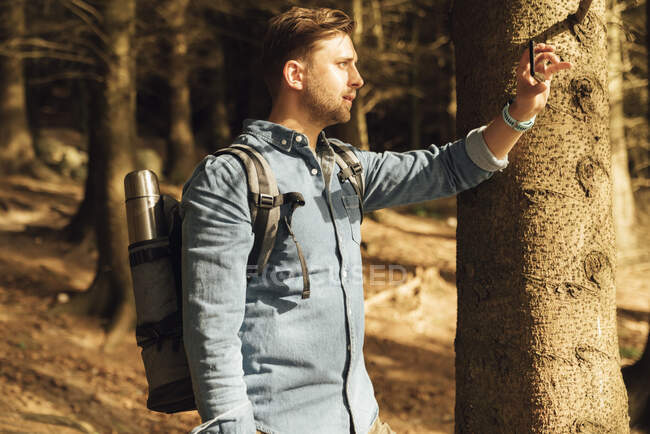 Homem adulto médio fotografando com telefone celular em pé na floresta — Fotografia de Stock
