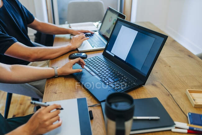 Web designers working while using laptop at office desk — Stock Photo