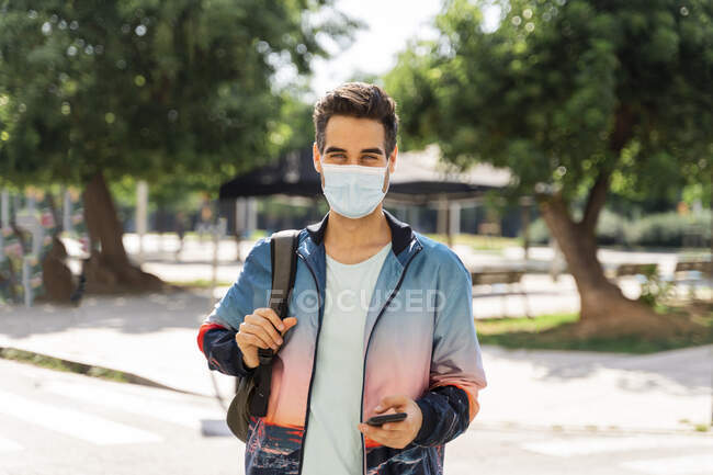 Человек в маске, стоящий в городе во время COVID-19 — стоковое фото