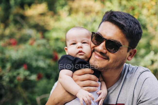 Loving man carrying cute son at park during weekend — Stock Photo