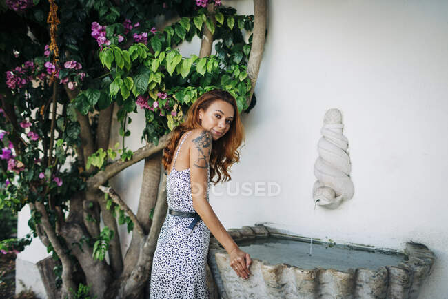 Beautiful woman standing by fountain at Alfama, Lisbon, Portugal — Stock Photo