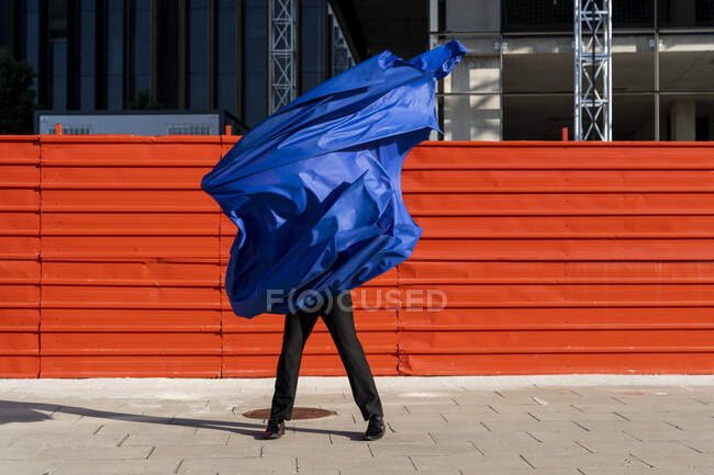 Hombre anónimo cubierto por capa azul - foto de stock