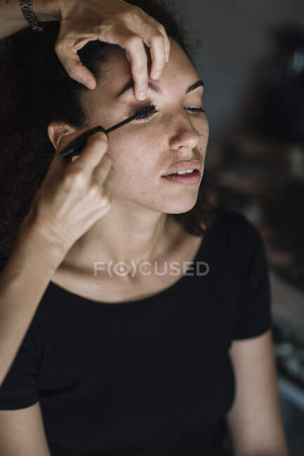 Make-up artist applying mascara on bride eye — Stock Photo