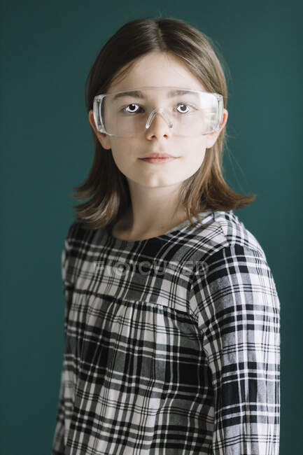 Gros plan de la jeune fille portant des lunettes avec les yeux googly tout en se tenant contre le mur — Photo de stock