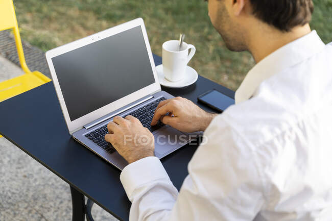 Close-up de homem de negócios trabalhando sobre laptop na mesa no café da calçada — Fotografia de Stock