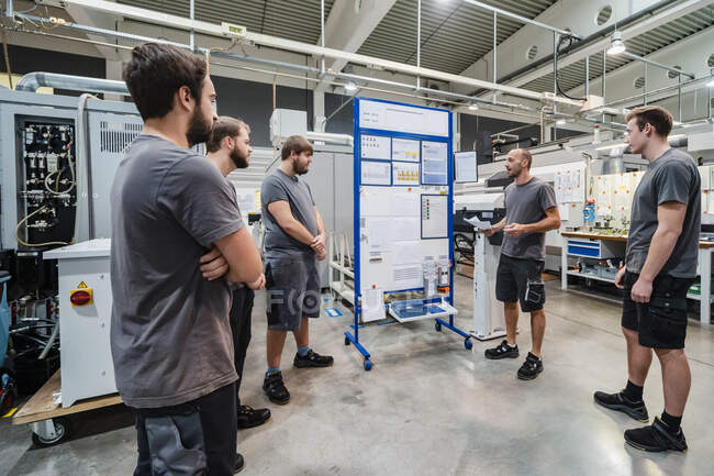 Maintenance worker having discussion while standing at industry — Stock Photo