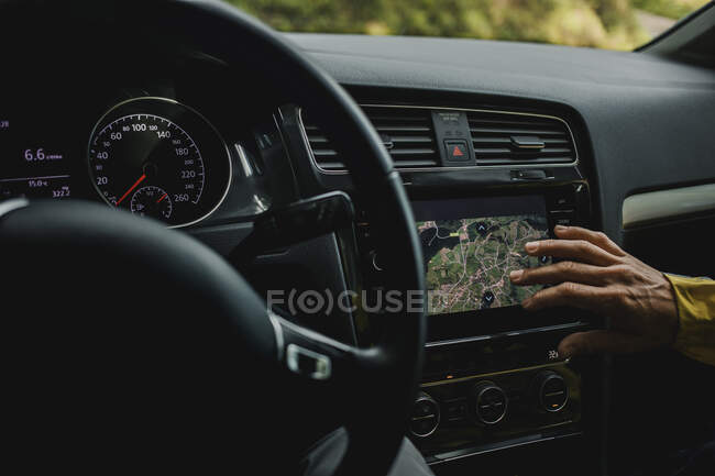 Main de femme vérifiant les cartes numériques en voiture pendant les vacances — Photo de stock
