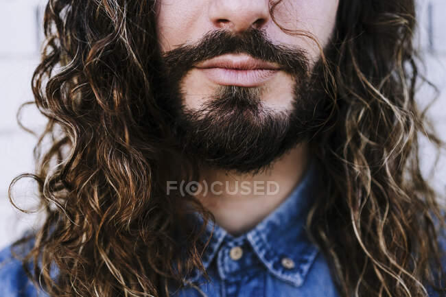 Jeune homme avec barbe et longs cheveux bruns — Photo de stock