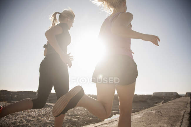 Freundinnen laufen an sonnigen Tagen am Strand — Stockfoto