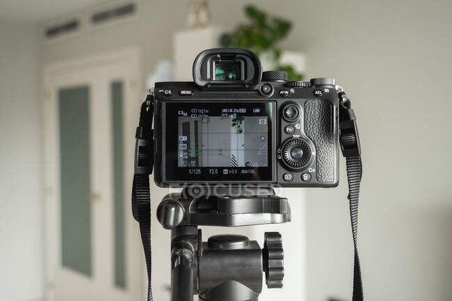 Close-up of digital camera on tripod in living room at home — Stock Photo