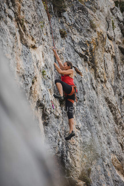 Donna determinata arrampicata montagna rocciosa — Foto stock