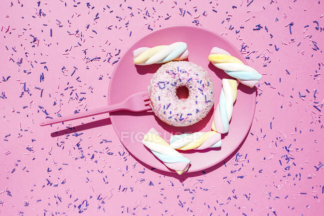 Studio shot of plate with marshmallows and doughnut with sugar sprinkles — Stock Photo