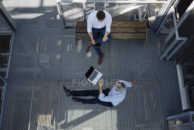 Männliche Fachkräfte diskutieren im Sitzen in Gärtnerei — Stockfoto