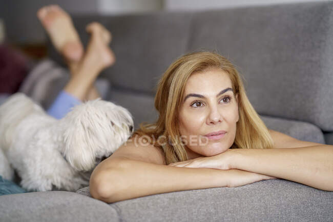 Pensativo mujer madura relajarse en el sofá en casa - foto de stock