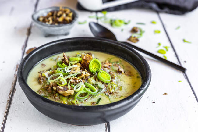 Bowl of vegetarian leek soup with cheese and roasted walnuts — Stock Photo