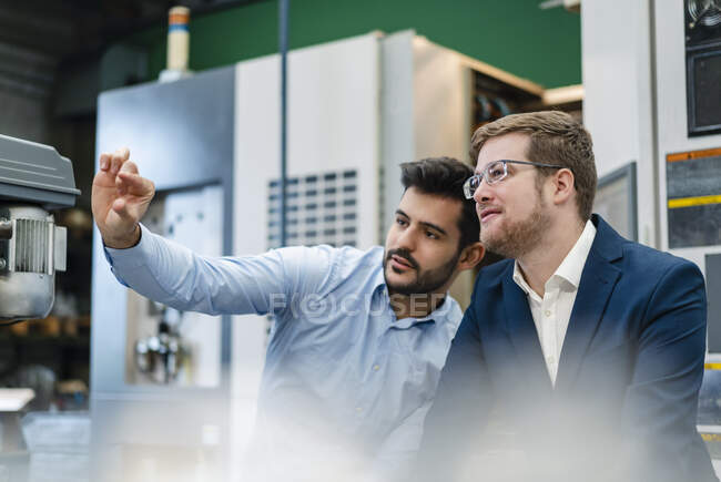 Manager doing hand gesture while discussing with businessman at factory — Stock Photo