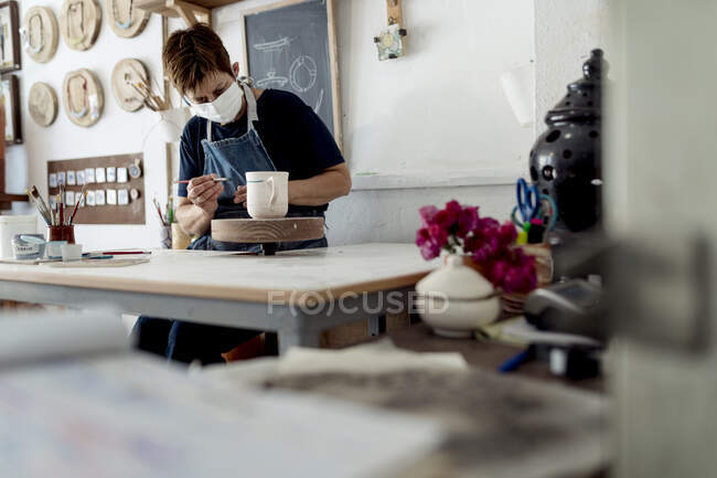 Copo de pintura de proprietário de pequenas empresas em sua oficina de artesanato — Fotografia de Stock