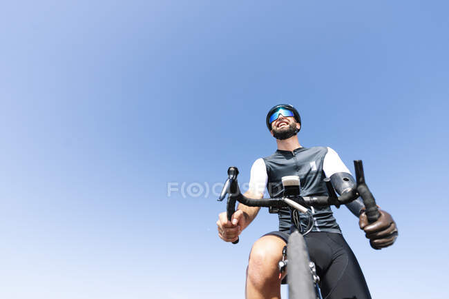Homme amputé cycliste avec un membre artificiel vélo d'équitation contre ciel clair — Photo de stock