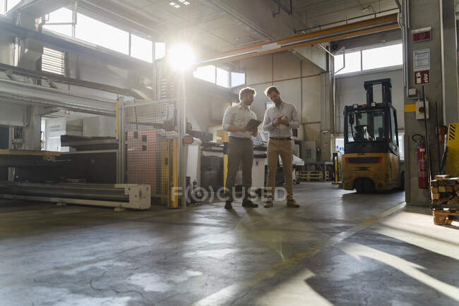 Business people working while standing at factory — Stock Photo