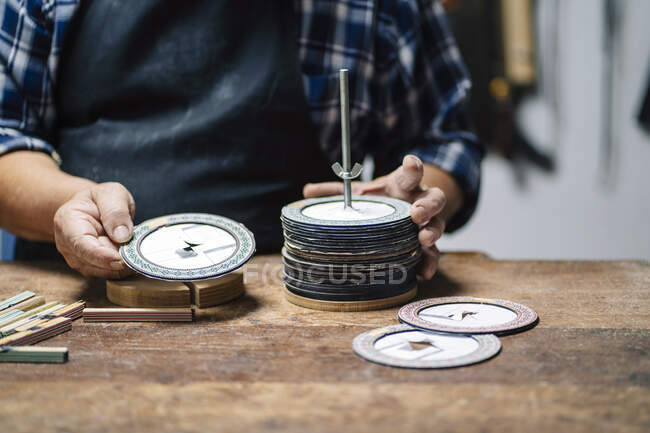 Luthier selezionando disco di carta mentre in piedi in officina — Foto stock
