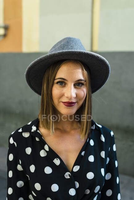 Крупним планом впевнена молода жінка в капелюсі, що стоїть в місті — стокове фото