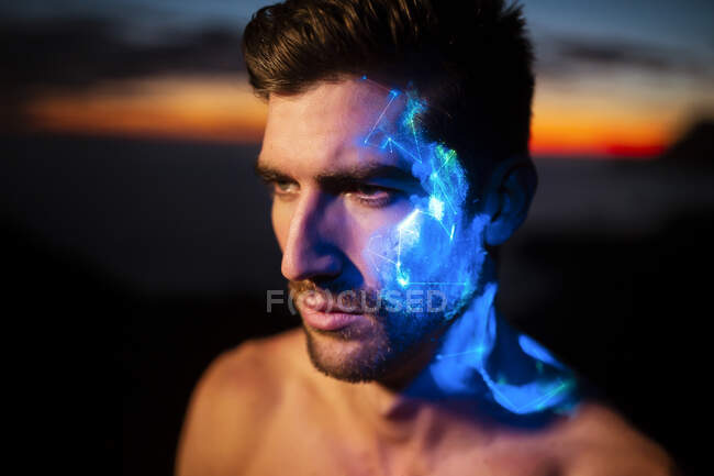 Contemplated young man with glowing face looking away — Stock Photo