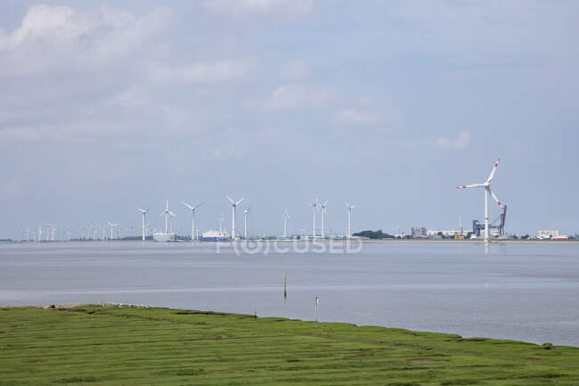 Germany, Lower Saxony, Emden, Wind turbines on bank of Ems — Stock Photo