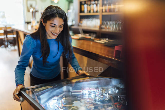 Attraktive Frau spielt Flipper in Bar — Stockfoto