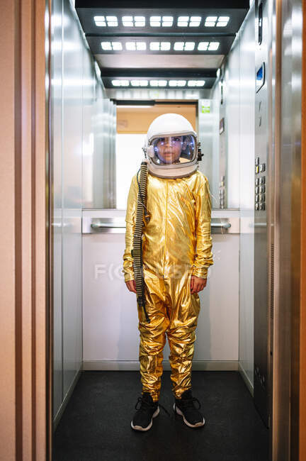 Мальчик в скафандре стоит в открытом лифте — стоковое фото