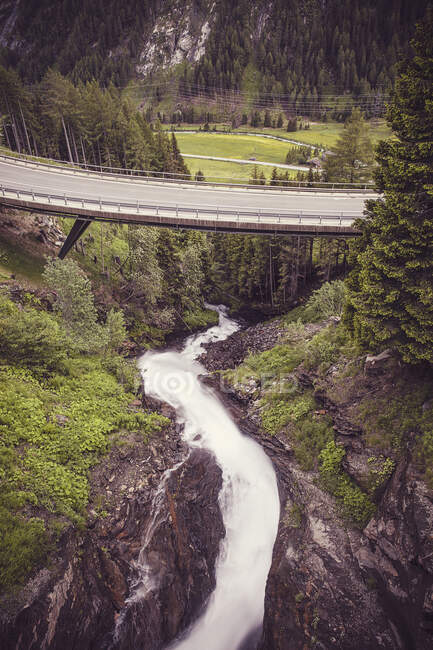 Pont autoroutier sur les éclaboussures de cascade dans les Alpes du Centre-Est — Photo de stock