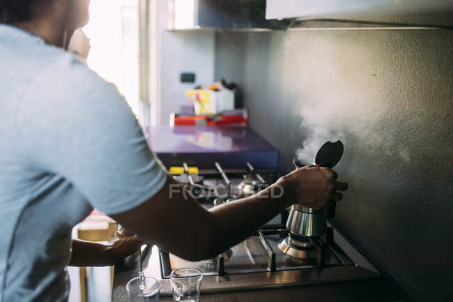 Nahaufnahme einer Frau, die auf Herd in Küche Kaffee kocht — Stockfoto