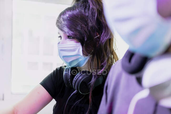 Musikerin trägt Gesichtsmaske von Freund im Tonstudio — Stockfoto