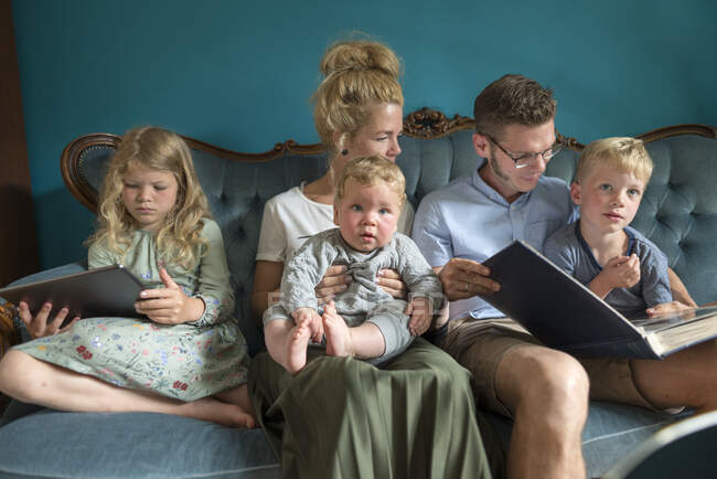 Famiglia seduta sul divano in soggiorno a casa durante il fine settimana — Foto stock