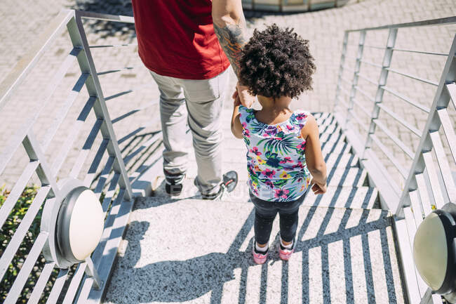 Padre che tiene le mani della figlia mentre sta in piedi sui gradini — Foto stock