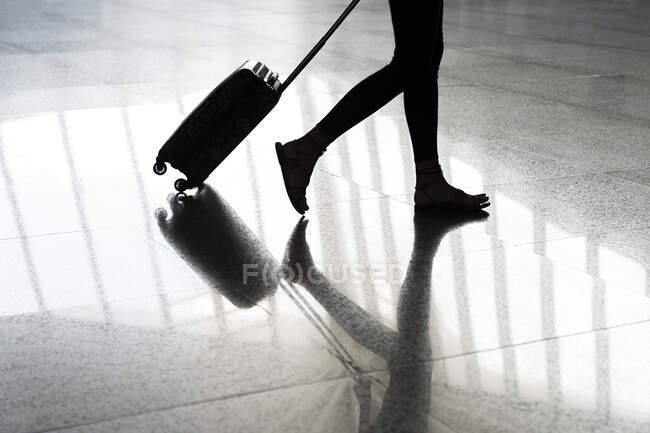 Legs of young woman walking towards airport — Stock Photo