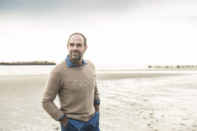 Mature man contemplating while standing at beach against sky — Stock Photo