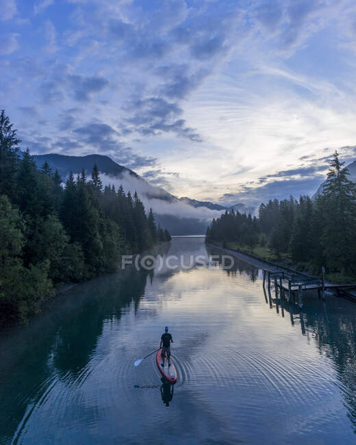 Man on sup board on Lake Plansee in the evening, Tyrol, Austria — Stock Photo