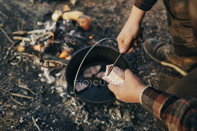 Bushcrafter cocinar en el bosque - foto de stock